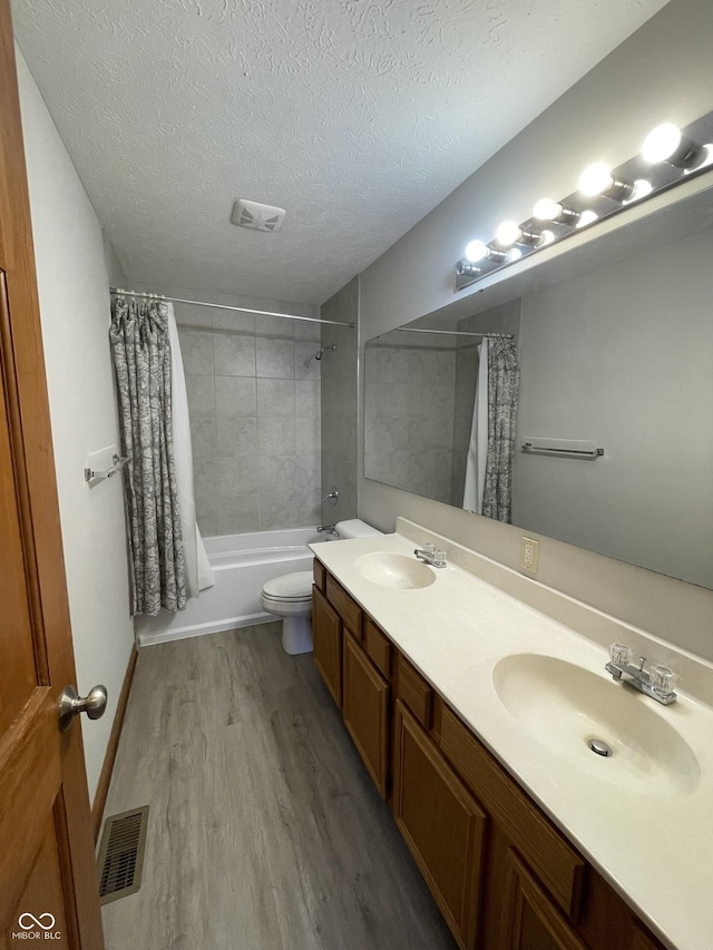 2068 Suda Dr, Carmel, IN 46280 - bathroom featuring wood finished floors, a textured ceiling, double vanity, and shower / tub combo