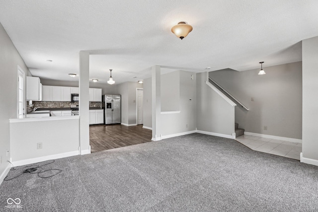 12632 Endurance Dr, Fishers, IN 46037 - unfurnished living room featuring carpet, stairs, and a textured ceiling