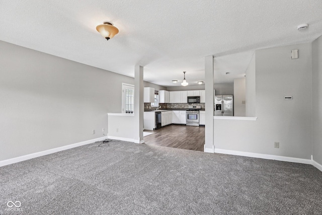 12632 Endurance Dr, Fishers, IN 46037 - unfurnished living room with dark carpet and a textured ceiling
