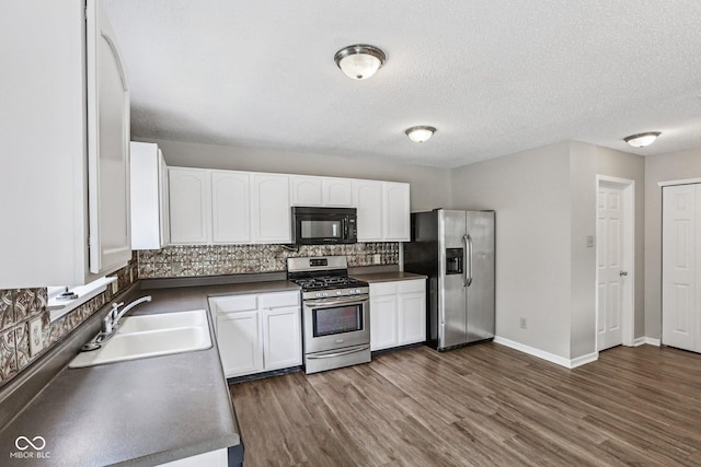 12632 Endurance Dr, Fishers, IN 46037 - kitchen featuring appliances with stainless steel finishes, dark countertops, tasteful backsplash, white cabinets, and dark wood-style flooring