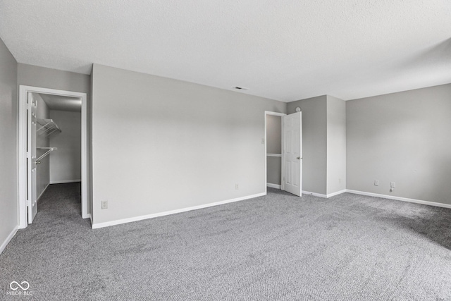 12632 Endurance Dr, Fishers, IN 46037 - unfurnished bedroom featuring carpet flooring, a textured ceiling, and a walk in closet