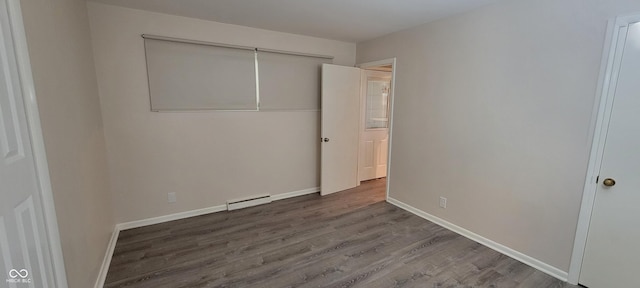 2611 Taylor Rd, Columbus, IN 47203 - unfurnished bedroom featuring wood finished floors and a baseboard heating unit