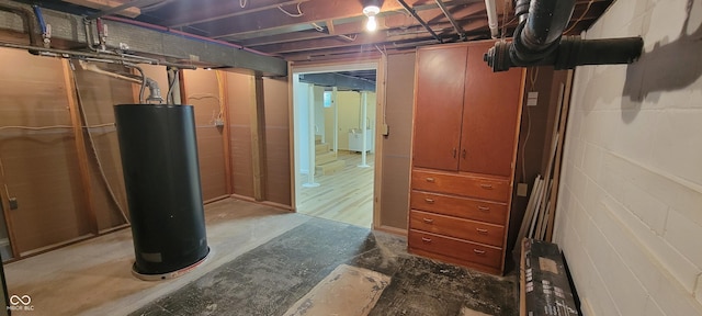 2611 Taylor Rd, Columbus, IN 47203 - unfinished below grade area featuring water heater, concrete block wall, and washer / dryer