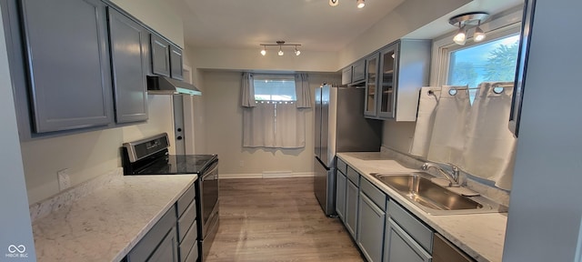 2611 Taylor Rd, Columbus, IN 47203 - kitchen featuring stainless steel appliances, under cabinet range hood, light stone counters, and wood finished floors