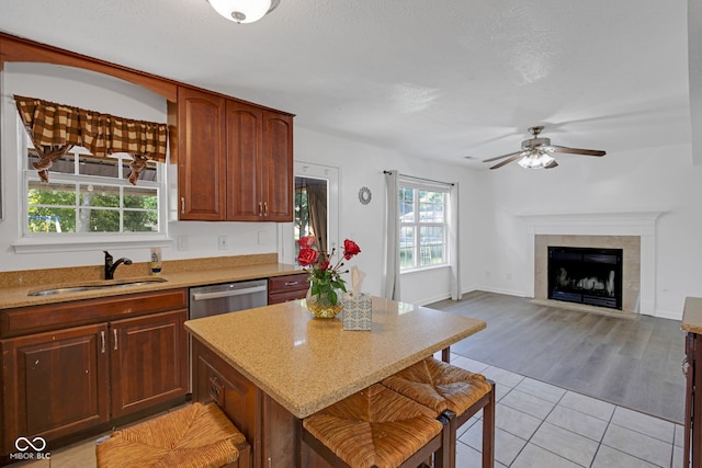 8850 Tanner Dr, Fishers, IN 46038 - kitchen with light tile patterned floors, a ceiling fan, a center island, dishwasher, and a kitchen breakfast bar