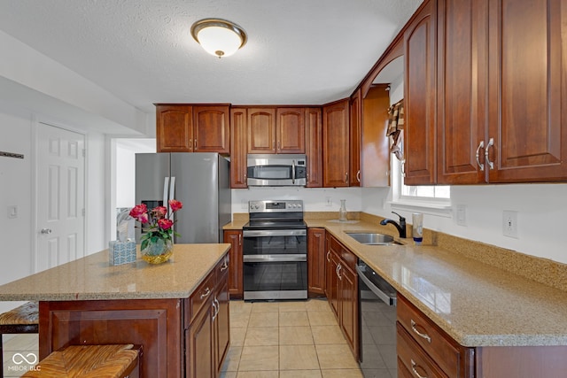 8850 Tanner Dr, Fishers, IN 46038 - kitchen featuring appliances with stainless steel finishes, light stone counters, a breakfast bar area, and light tile patterned flooring