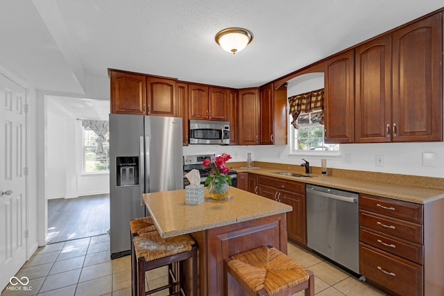 8850 Tanner Dr, Fishers, IN 46038 - kitchen with stainless steel appliances, light tile patterned floors, a kitchen island, and a kitchen bar