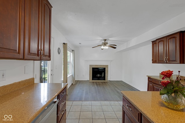 8850 Tanner Dr, Fishers, IN 46038 - kitchen with ceiling fan, a tile fireplace, light stone countertops, and light tile patterned floors
