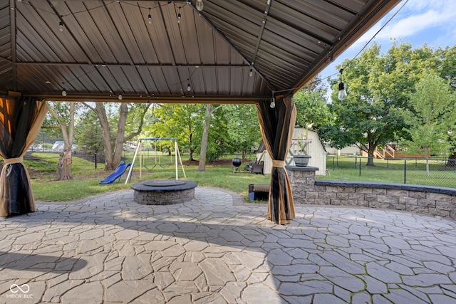 8850 Tanner Dr, Fishers, IN 46038 - fenced backyard featuring an outdoor fire pit, a patio, a playground, and view of wooded area