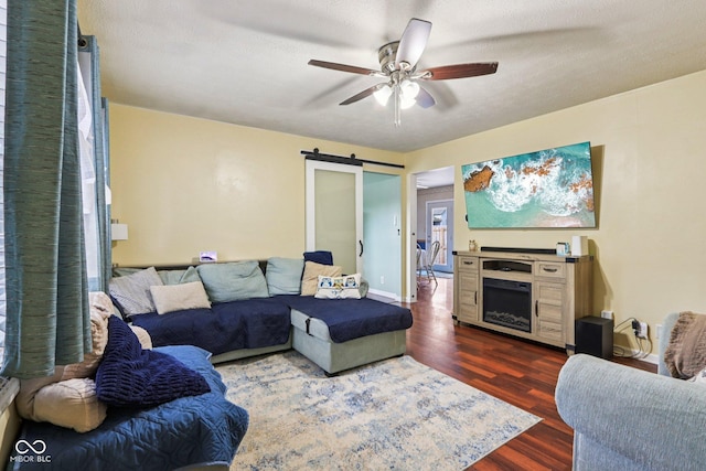 121 Apple St, Greenfield, IN 46140 - living room with dark wood-style floors, ceiling fan, a barn door, and a fireplace