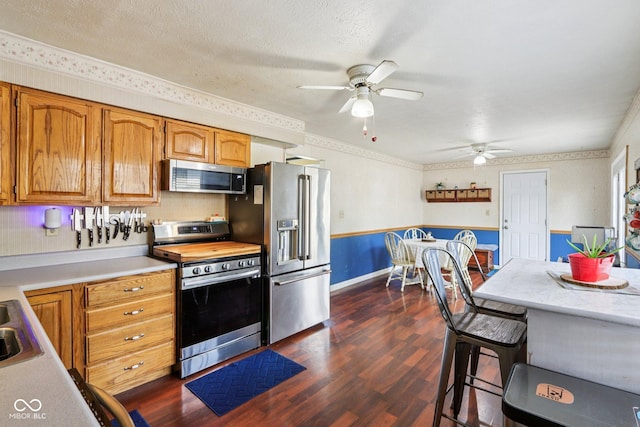 121 Apple St, Greenfield, IN 46140 - kitchen with stainless steel appliances, light countertops, ceiling fan, dark wood-style floors, and crown molding