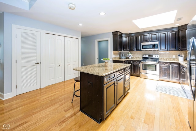 20971 Shoreline Ct Unit 408, Noblesville, IN 46062 - kitchen with stainless steel appliances, a skylight, light wood-type flooring, tasteful backsplash, and recessed lighting