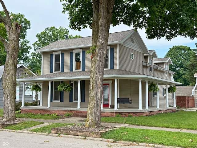 416 6th St, Covington, IN 47932 - farmhouse inspired home featuring a porch, roof with shingles, and a front lawn