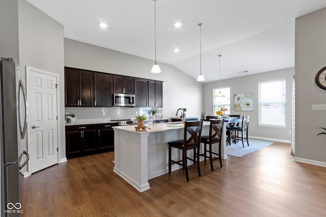 9801 Zion Way, Pendleton, IN 46064 - kitchen with appliances with stainless steel finishes, vaulted ceiling, dark wood-type flooring, a breakfast bar, and tasteful backsplash