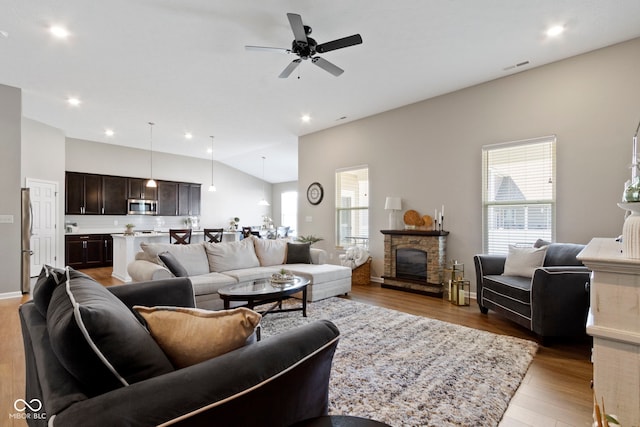 9801 Zion Way, Pendleton, IN 46064 - living room featuring light wood-style floors, lofted ceiling, ceiling fan, recessed lighting, and a stone fireplace