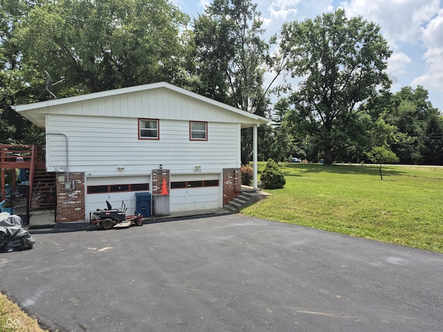 7802 Fall Creek Rd, Indianapolis, IN 46256 - view of property exterior featuring an attached garage, brick siding, asphalt driveway, a yard, and stairway