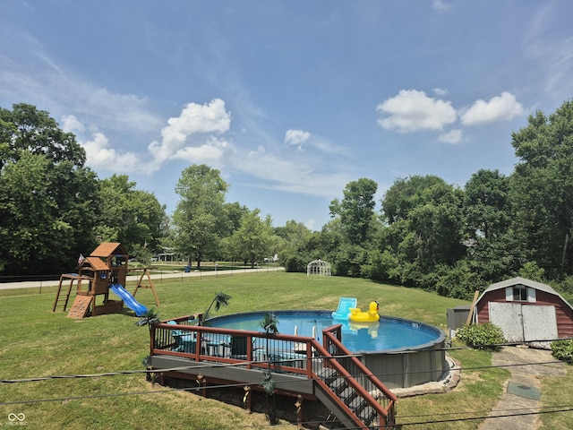 7802 Fall Creek Rd, Indianapolis, IN 46256 - view of play area with an outdoor pool, a storage unit, a lawn, and view of scattered trees