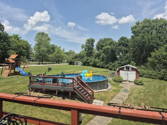 7802 Fall Creek Rd, Indianapolis, IN 46256 - view of grassy yard featuring an outdoor pool, a playground, a deck, a storage unit, and view of scattered trees