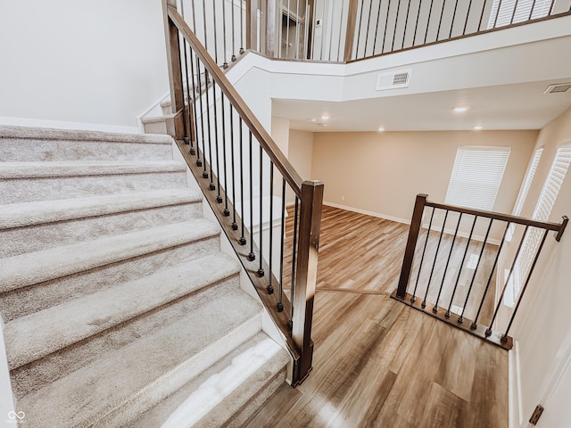 3522 Brampton Ln, Westfield, IN 46074 - staircase featuring wood finished floors, a high ceiling, and recessed lighting