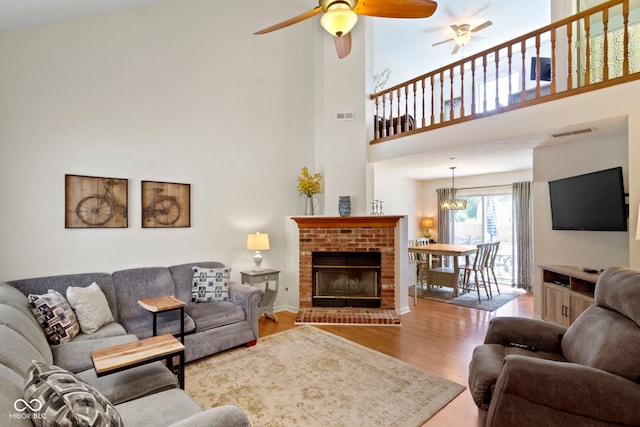 5034 Aspen Crest Ln, Indianapolis, IN 46254 - living room featuring a ceiling fan, wood finished floors, a chandelier, a high ceiling, and a fireplace