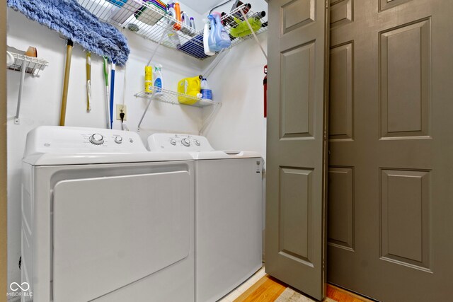 5034 Aspen Crest Ln, Indianapolis, IN 46254 - washroom with washing machine and clothes dryer and light wood-type flooring