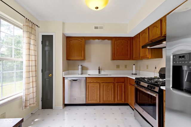 5034 Aspen Crest Ln, Indianapolis, IN 46254 - kitchen featuring stainless steel appliances, under cabinet range hood, light floors, and brown cabinets