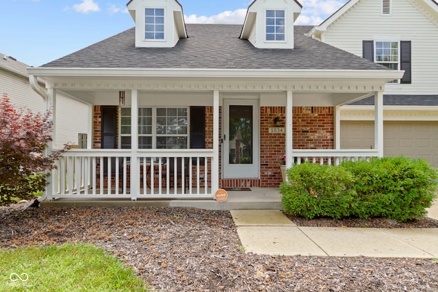 5034 Aspen Crest Ln, Indianapolis, IN 46254 - entrance to property featuring covered porch, a shingled roof, brick siding, and an attached garage