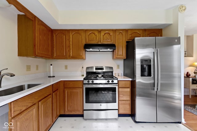 5034 Aspen Crest Ln, Indianapolis, IN 46254 - kitchen featuring appliances with stainless steel finishes, under cabinet range hood, brown cabinets, and light countertops