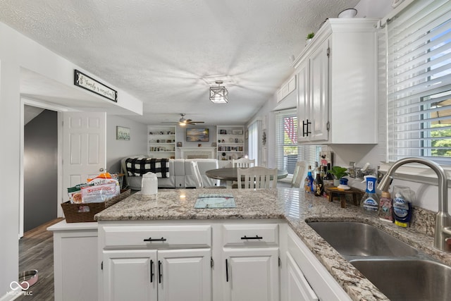 10532 Beacon Ln, Indianapolis, IN 46256 - kitchen featuring a peninsula, a ceiling fan, a textured ceiling, and white cabinets