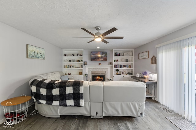 10532 Beacon Ln, Indianapolis, IN 46256 - living area featuring a ceiling fan, wood finished floors, a fireplace, and a textured ceiling