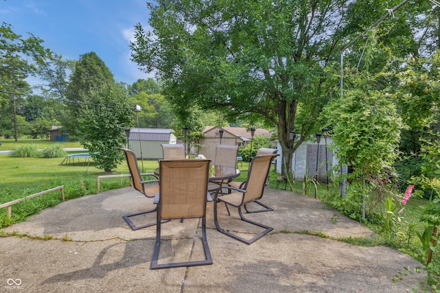 157 E Hill Valley Dr, Indianapolis, IN 46227 - view of patio featuring a storage unit, outdoor dining space, and a trampoline