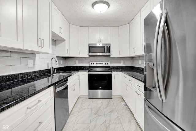 1065 Chevy Chase Ln, Carmel, IN 46280 - kitchen featuring stainless steel appliances, light marble finish flooring, white cabinetry, and a textured ceiling