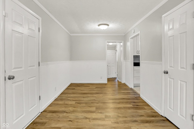 1065 Chevy Chase Ln, Carmel, IN 46280 - hallway featuring wainscoting, light wood finished floors, crown molding, and a textured ceiling