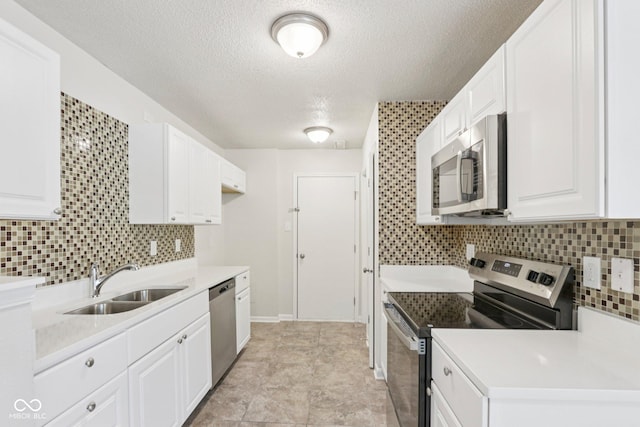 2629 Redland Ln, Indianapolis, IN 46217 - kitchen featuring stainless steel appliances, decorative backsplash, a textured ceiling, white cabinets, and light countertops