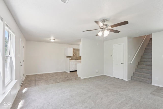 2629 Redland Ln, Indianapolis, IN 46217 - unfurnished living room with stairway, a ceiling fan, and light colored carpet