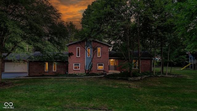 812 Eaglewood Dr, Zionsville, IN 46077 - tri-level home with brick siding, a lawn, a playground, a garage, and driveway