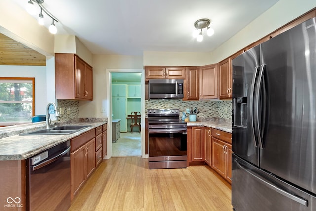 812 Eaglewood Dr, Zionsville, IN 46077 - kitchen featuring stainless steel appliances, light wood finished floors, tasteful backsplash, and brown cabinets