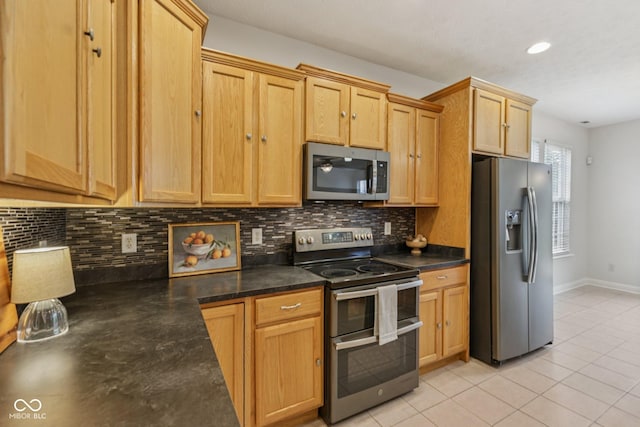 1272 Townsend Dr, Greenwood, IN 46143 - kitchen featuring stainless steel appliances, dark countertops, backsplash, light tile patterned floors, and recessed lighting