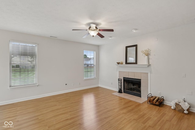 1272 Townsend Dr, Greenwood, IN 46143 - unfurnished living room featuring ceiling fan, light wood-style floors, and a tile fireplace