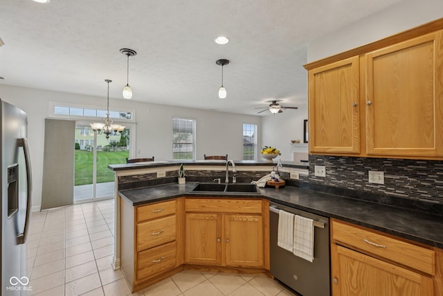 1272 Townsend Dr, Greenwood, IN 46143 - kitchen with stainless steel appliances, a peninsula, light tile patterned floors, a chandelier, and backsplash