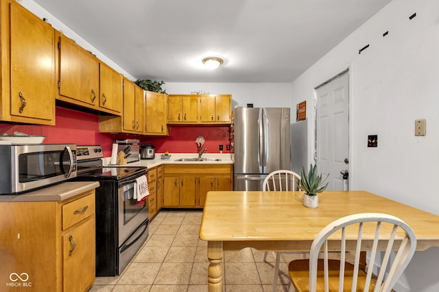 3909 Richelieu Ct, Indianapolis, IN 46226 - kitchen with stainless steel appliances, light countertops, light tile patterned floors, and brown cabinetry