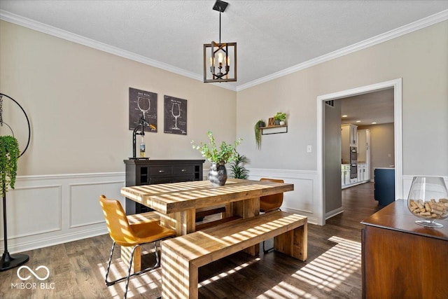 11322 Sea Side Ct, Fishers, IN 46040 - dining space featuring dark wood finished floors, a chandelier, ornamental molding, a wainscoted wall, and a decorative wall