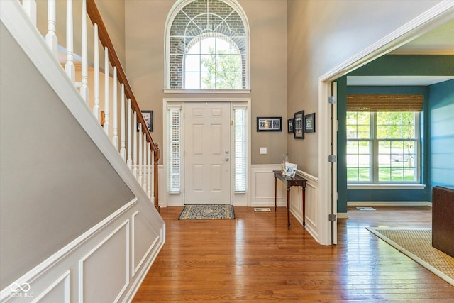 13059 Cirrus Dr, Fishers, IN 46037 - entryway with wood finished floors, a wainscoted wall, a high ceiling, stairway, and a decorative wall
