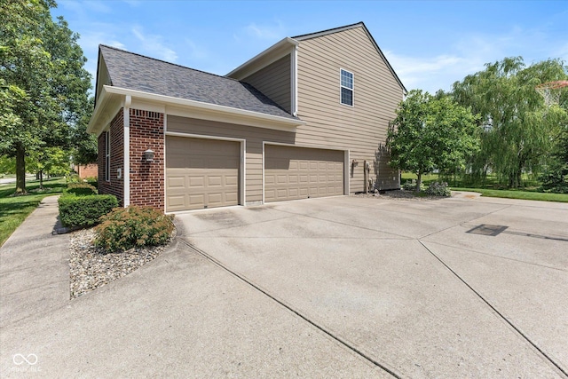 13059 Cirrus Dr, Fishers, IN 46037 - view of side of home with driveway, a shingled roof, brick siding, and an attached garage