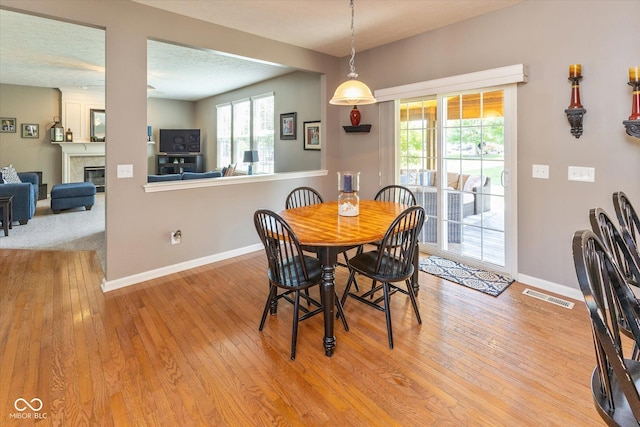 13059 Cirrus Dr, Fishers, IN 46037 - dining area with plenty of natural light, hardwood / wood-style flooring, and a tile fireplace