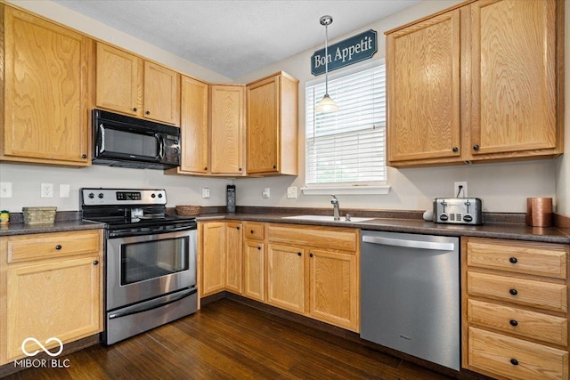 16009 Tenor Way, Noblesville, IN 46060 - kitchen with stainless steel appliances, dark countertops, dark wood-style flooring, and hanging light fixtures