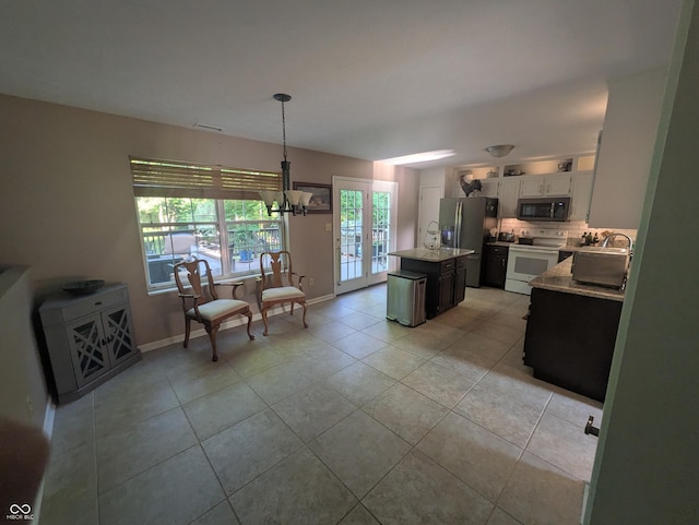 7327 Newbury Ct, Fishers, IN 46038 - kitchen featuring white electric range oven, stainless steel fridge with ice dispenser, tasteful backsplash, a center island, and light tile patterned floors