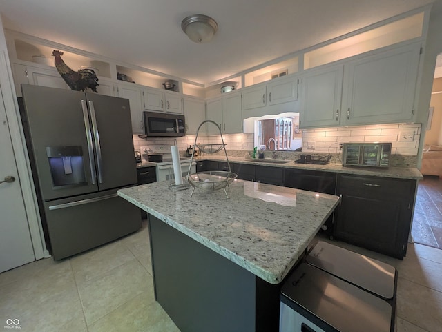 7327 Newbury Ct, Fishers, IN 46038 - kitchen featuring stainless steel refrigerator with ice dispenser, white range with electric stovetop, decorative backsplash, and light stone counters