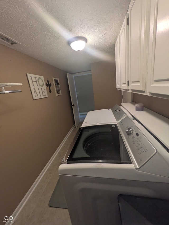 7327 Newbury Ct, Fishers, IN 46038 - washroom with cabinet space, washing machine and clothes dryer, a textured ceiling, and tile patterned floors
