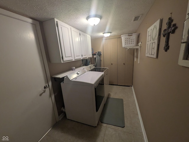 7327 Newbury Ct, Fishers, IN 46038 - washroom featuring washer and clothes dryer, cabinet space, light tile patterned floors, and a textured ceiling